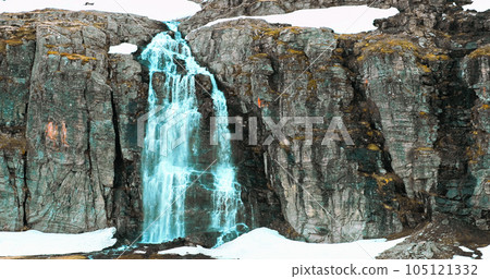 Aurlandsfjellet, Norway. Waterfall Flotvatnet In Spring Snowy Landscape. Natural Norwegian Landmark And Popular Destination. Concept Of Advertisement Water, Alcohol Or Active Life. Slow Mo, Slo Motion 105121332