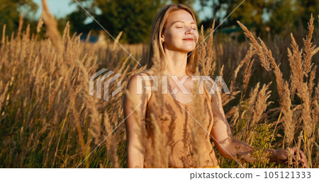 Portrait Of Young Pretty Caucasian Happy Girl Woman Use Breathing Programs At Summer Meadow. Healthy Lifestyle Concept. Unity With Nature. Calmness And Tranquility. Yoga Concept Lifestyle 105121333