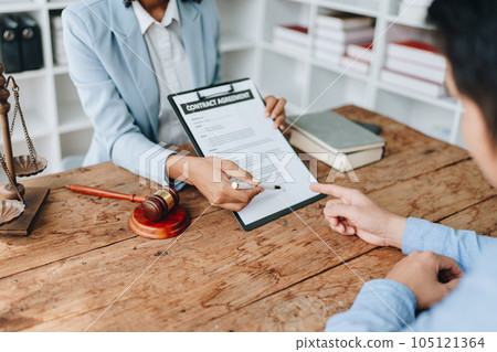 Young African American lawyer studying a case for a client and signing a legal contract to fight her opponent in court. Legal and lawyer concepts 105121364