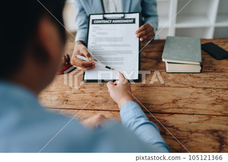 Young African American lawyer studying a case for a client and signing a legal contract to fight her opponent in court. Legal and lawyer concepts 105121366
