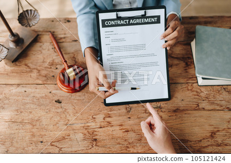 Young African American lawyer studying a case for a client and signing a legal contract to fight her opponent in court. Legal and lawyer concepts 105121424