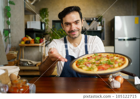 Man baking a pizza. 105122715