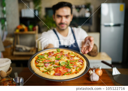 Man baking a pizza. 105122716