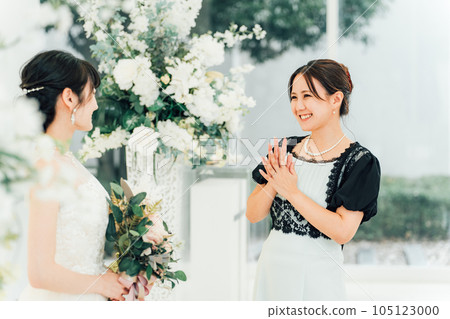 A bride and a guest, friend, relative woman talking at a wedding reception A bride and a guest, friend, relative woman talking at a wedding reception 105123000