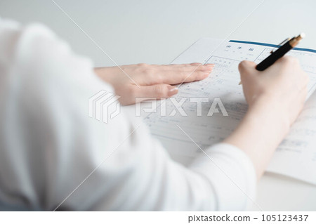 A woman's hand filling out a birth certificate A woman's hand filling out a birth certificate 105123437