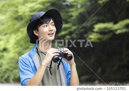 A young man birdwatching on the river bed 105123701