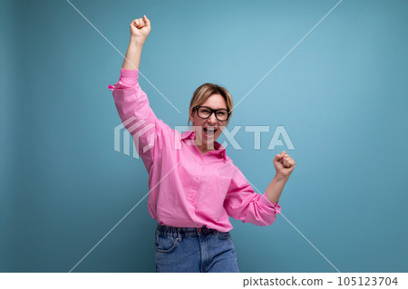 young positive well-groomed caucasian blond office worker woman dressed in pink shirt and jeans and 105123704