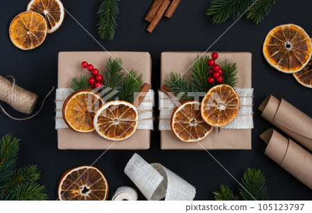 Craft gift boxes with dried oranges, spruce branches and berries Craft gift boxes with dried oranges, spruce branches and berries 105123797