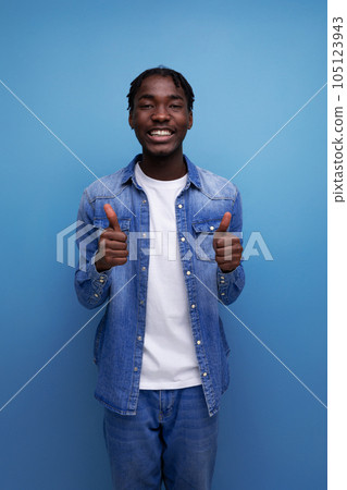close-up portrait of an energetic explosive young stylish american guy with dreadlocks in a denim 105123943