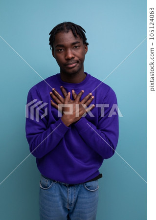 calm african young man with dreadlocks with hands on chest in studio background 105124063