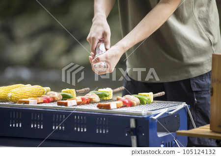 燒烤圖像一個年輕人在串上撒鹽 105124132