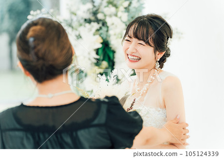 A smiling bride/bride talking to guests/friends/relatives at a wedding reception/party 105124339