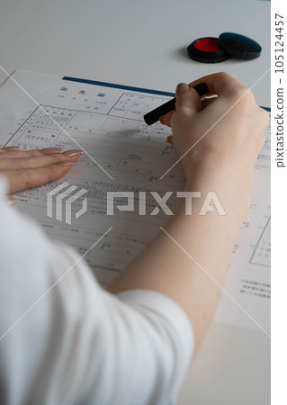 A woman's hand stamping a birth certificate 105124457