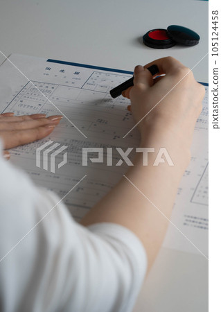 A woman's hand stamping a birth certificate A woman's hand stamping a birth certificate 105124458