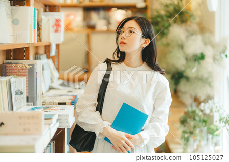 young woman in a bookstore young woman in a bookstore 105125027