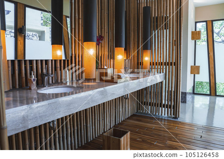 Luxury modern hotel bathroom interior detail. Hand towel, soap dispenser and sink basin on a marble top at Costa Rica. Luxury travel vacation concept 105126458