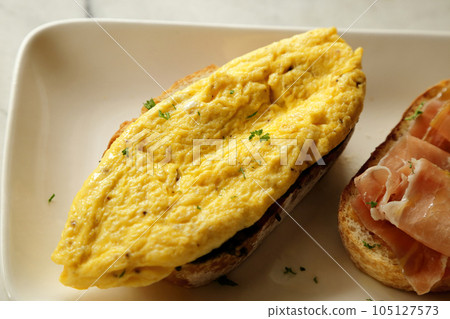 Breakfast dish. Open-Faced Sandwich - omelette on toasted bread. Breakfast dish. Open-Faced Sandwich - omelette on toasted bread. 105127573
