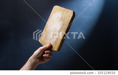 Hand holding kitchen board 105129010