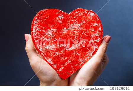 Hand holding red heart 105129011