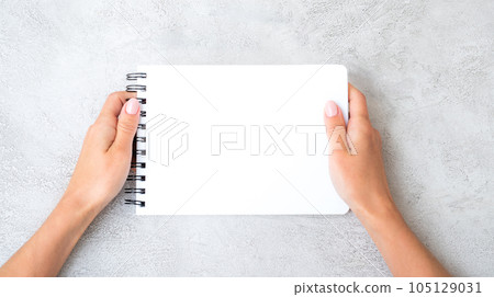 Girl's hands holding notebook 105129031