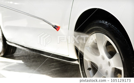 Washing a car in a self-service car wash station 105129173