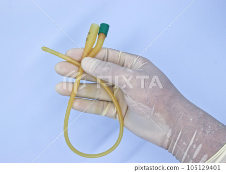 nurse holding urinary catheter prior to use. nurse holding urinary catheter prior to use. 105129401