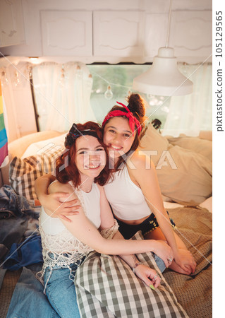 Portrait of a cute lesbian couple. Two girls spend time tenderly together in a camper trailer. Love and attitude. LGBT concept Portrait of a cute lesbian couple. Two girls spend time tenderly together in a camper trailer. Love and attitude. LGBT concept 105129565