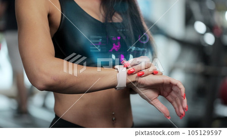 Close up of woman in gym looks at smart watch with body health indicator checking heartbeat. Future technology concept of humanity. 3D render animation. 105129597
