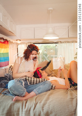 Portrait of a cute lesbian couple. Two girls spend time tenderly together in a camper trailer. Love and attitude. LGBT concept 105131048