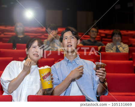 Scared young couple watching a horror movie Scared young couple watching a horror movie 105131669