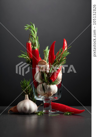 Red hot chili peppers, garlic, and rosemary on a black background. Red hot chili peppers, garlic, and rosemary on a black background. 105132826
