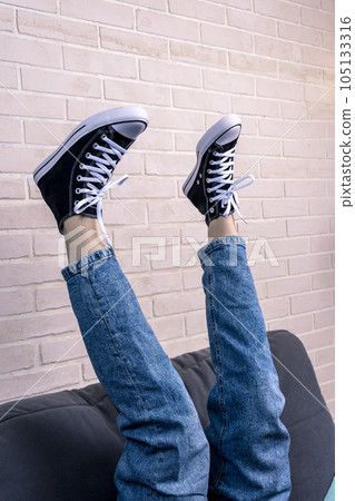 girl, is lying on the sofa with her legs thrown up girl, is lying on the sofa with her legs thrown up 105133316