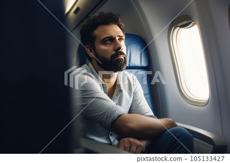 A person sitting on an airplane, looking disappointed. Generative AI 105133427