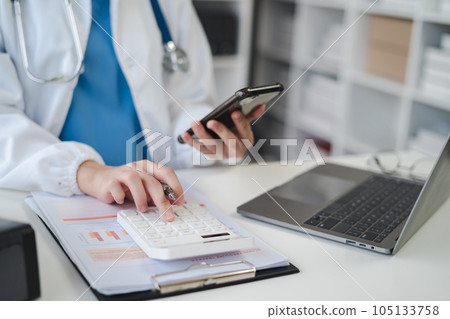 Doctor working in hospital use calculator, Healthcare and medical concept. Doctor working in hospital use calculator, Healthcare and medical concept. 105133758