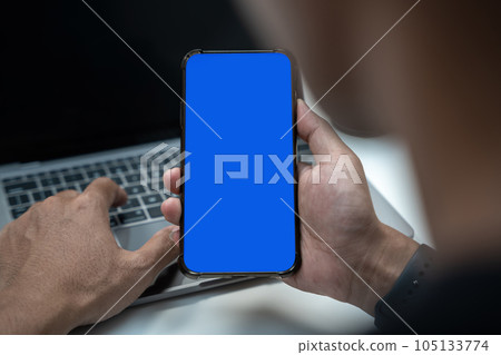 Man holding smartphone with blank screen, close-up of hands. Space for text. 105133774