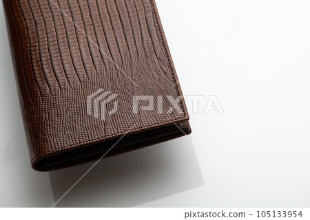 Close-up shot of a fashionable leather men's wallet on a white background with reflection 105133954