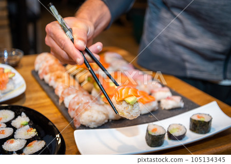 Overhead japanese sushi food. Maki ands rolls with tuna, salmon, shrimp, crab and avocado. Top view of assorted sushi. Overhead japanese sushi food. Maki ands rolls with tuna, salmon, shrimp, crab and avocado. Top view of assorted sushi. 105134345