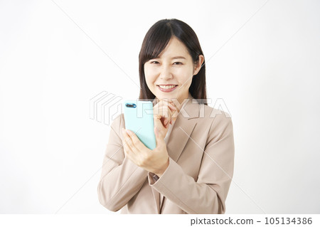 使用智能手機的中年女商人，白色背景，看著相機 105134386