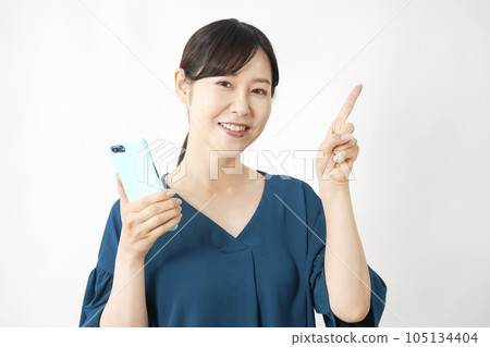一位女士拿著智能手機並指向右側的白色背景 105134404