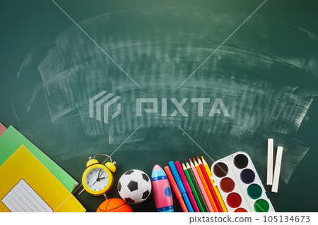 chool supplies on green chalkboard, flat lay with space for text. 105134673
