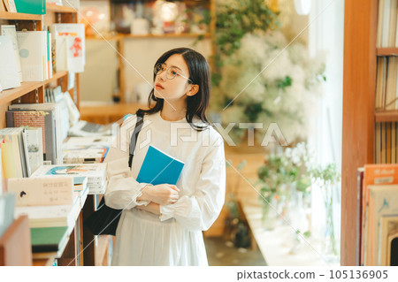 Young woman looking for a book in a bookstore Young woman looking for a book in a bookstore 105136905