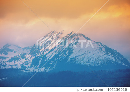 Beautiful snow-capped mountains against the backdrop of a sunset sky with dramatic clouds. Liptovsky Sea Region, High Tatras, Slovak Republic, Europe 105136916