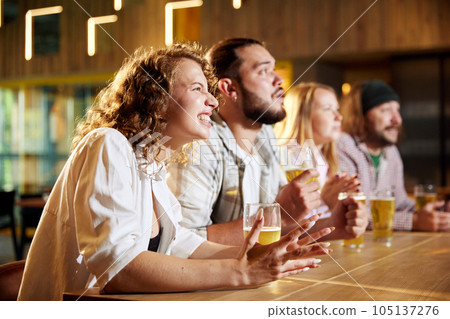 Sport fans, friends sitting at pub, bar, watching online football match translation, drinking beer, cheering up team Sport fans, friends sitting at pub, bar, watching online football match translation, drinking beer, cheering up team 105137276