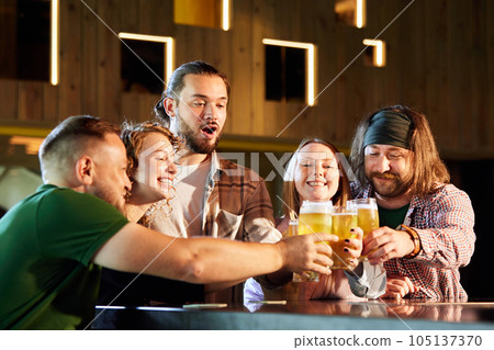 Friends, men and women attending pub, bar, watching sport match translation, drinking beer, cheering up favourite team 105137370