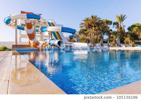 Empty small aquapark sliders with pool and palm trees at the morning, Tunisia Empty small aquapark sliders with pool and palm trees at the morning, Tunisia 105138106
