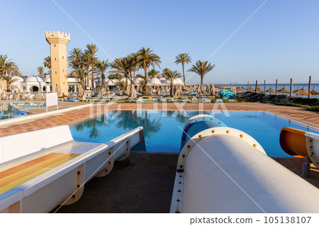 Empty small aquapark sliders with pool and palm trees at the morning, Tunisia 105138107