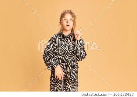 Portrait surprised intellectual girl having good great idea isolated over sandy color background. Concept of idea, answer, analyze, question Portrait surprised intellectual girl having good great idea isolated over sandy color background. Concept of idea, answer, analyze, question 105138435