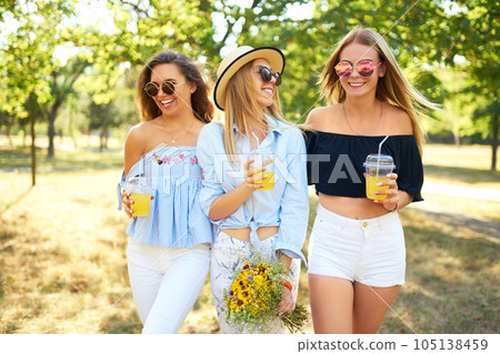 Three nice girls having fun In the park and make selfie. Excellent sunny weather. Beautiful figures. 105138459