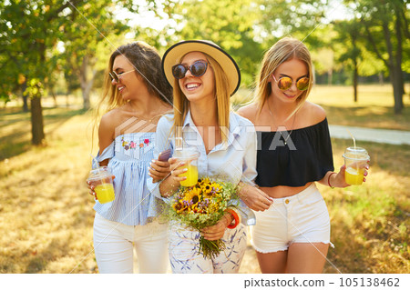 Three nice girls having fun In the park and make selfie. Excellent sunny weather. Beautiful figures. 105138462