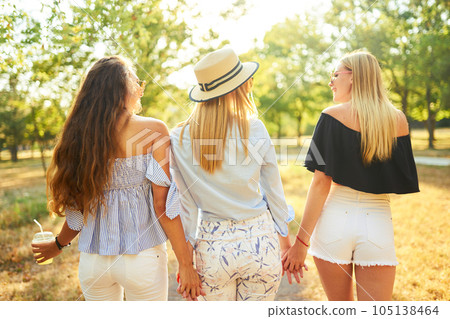 Three nice girls having fun In the park and make selfie. Excellent sunny weather. Beautiful figures. 105138464